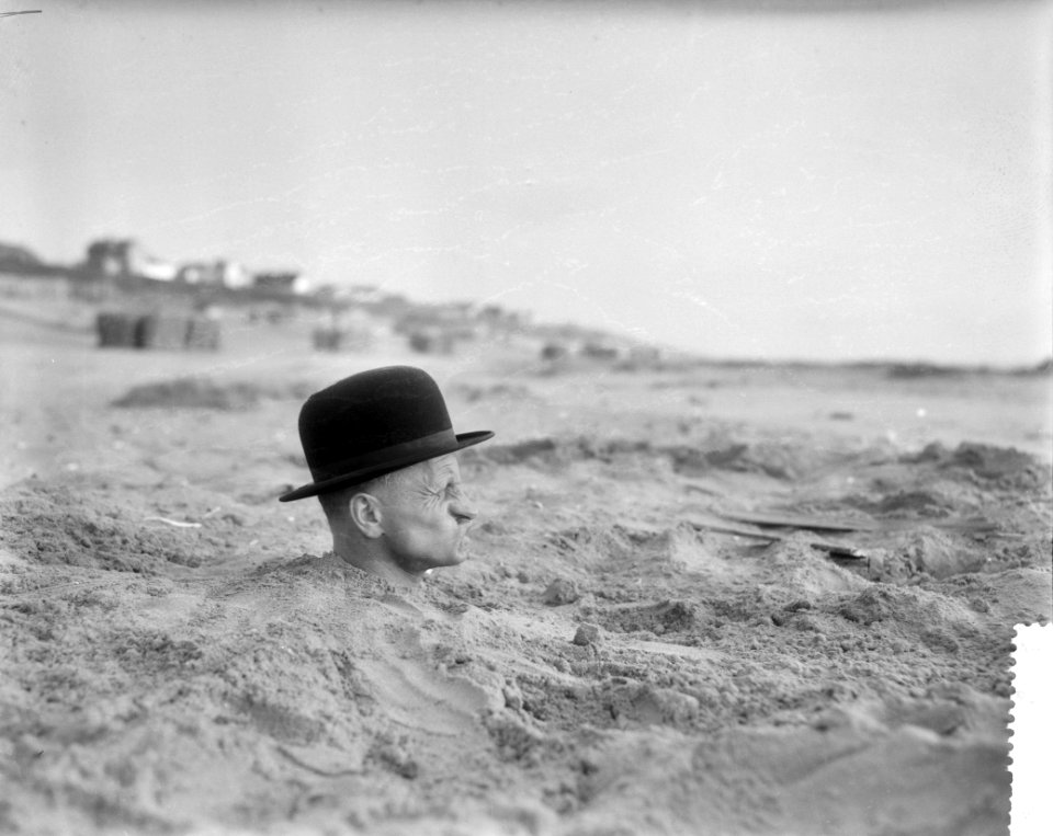 Vreemde situatie aan het Nederlandse strand, man met hele lichaam in het zand, Bestanddeelnr 910-3933