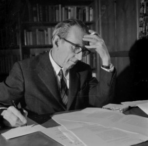 Walter Mehring schrijvend en rokend achter een bureau, Bestanddeelnr 254-5073