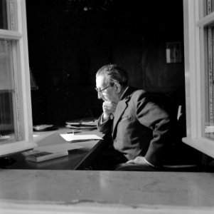 Walter Mehring lezend achter een bureau, Bestanddeelnr 254-5078