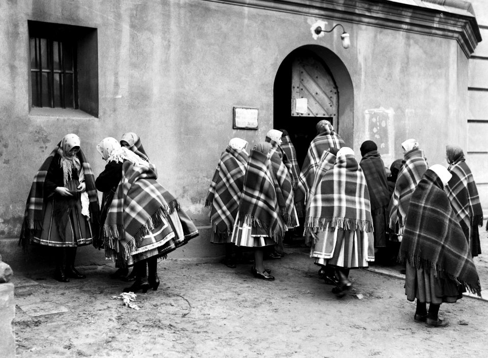 Vrouwen brengen in Lowicz hun kleding in orde voordat ze de kerk betreden, Bestanddeelnr 252-1299