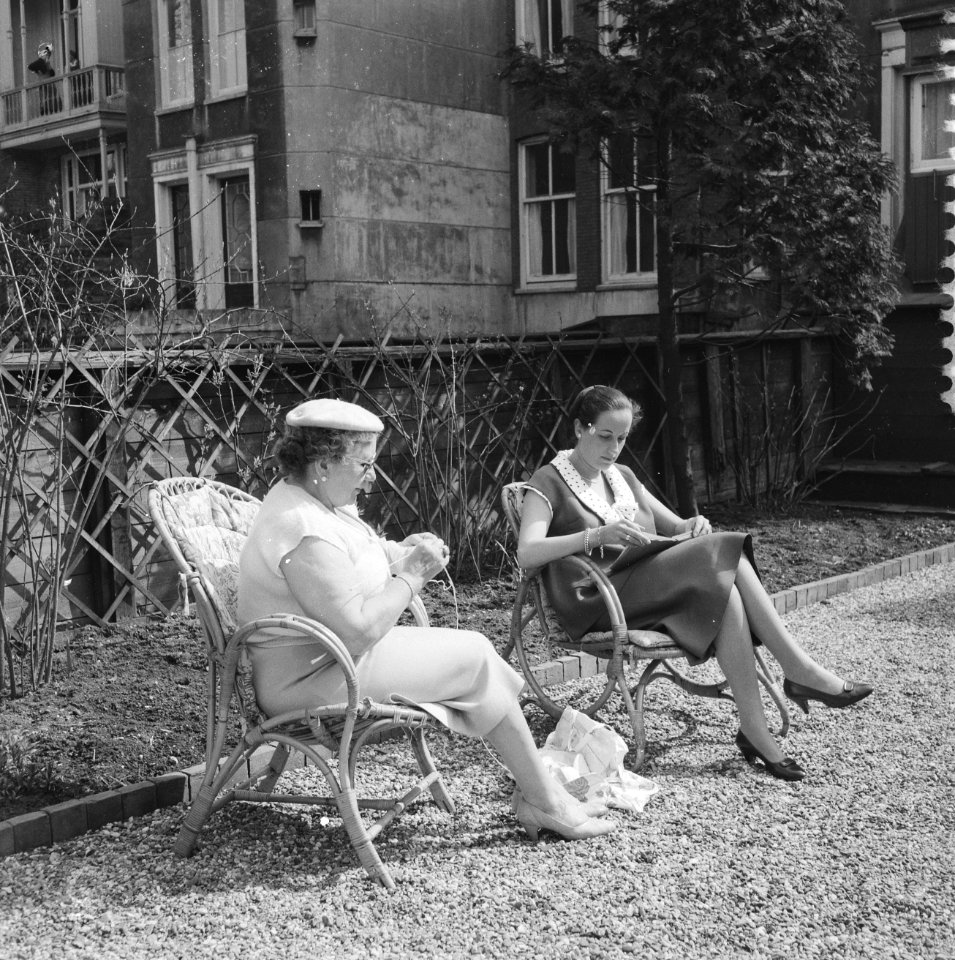 Vrouwen die in de tuin zitten te lezen en te breien in eerste mooie lentedag, Bestanddeelnr 909-5092