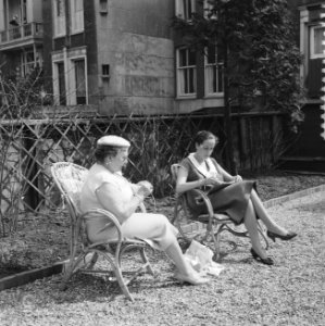 Vrouwen die in de tuin zitten te lezen en te breien in eerste mooie lentedag, Bestanddeelnr 909-5092