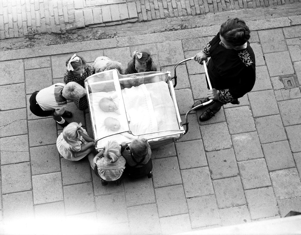 Vrouw met kinderwagen met tweelingen, andere kinderen bekijken de baby's, Bestanddeelnr 934-5115