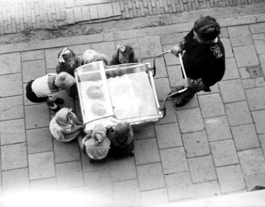 Vrouw met kinderwagen met tweelingen, andere kinderen bekijken de baby's, Bestanddeelnr 934-5115