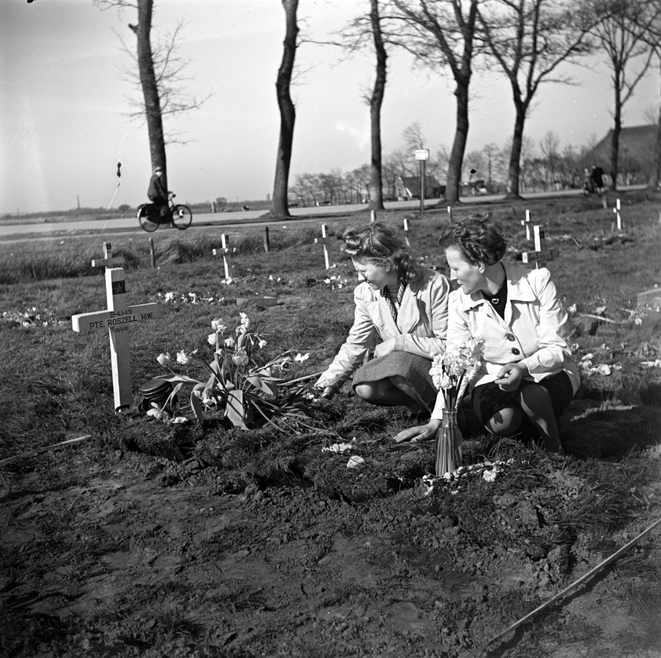Vrouwen leggen bloemen op het graf van de Canadese militair HW Roszell, Bestanddeelnr 900-2648