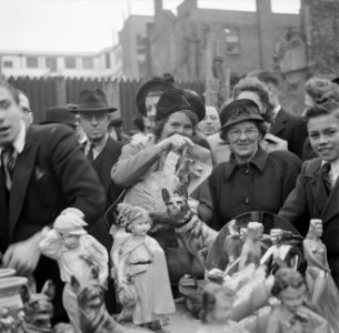 Vrouwen kijken naar beeldjes op een kraam, Bestanddeelnr 191-0939