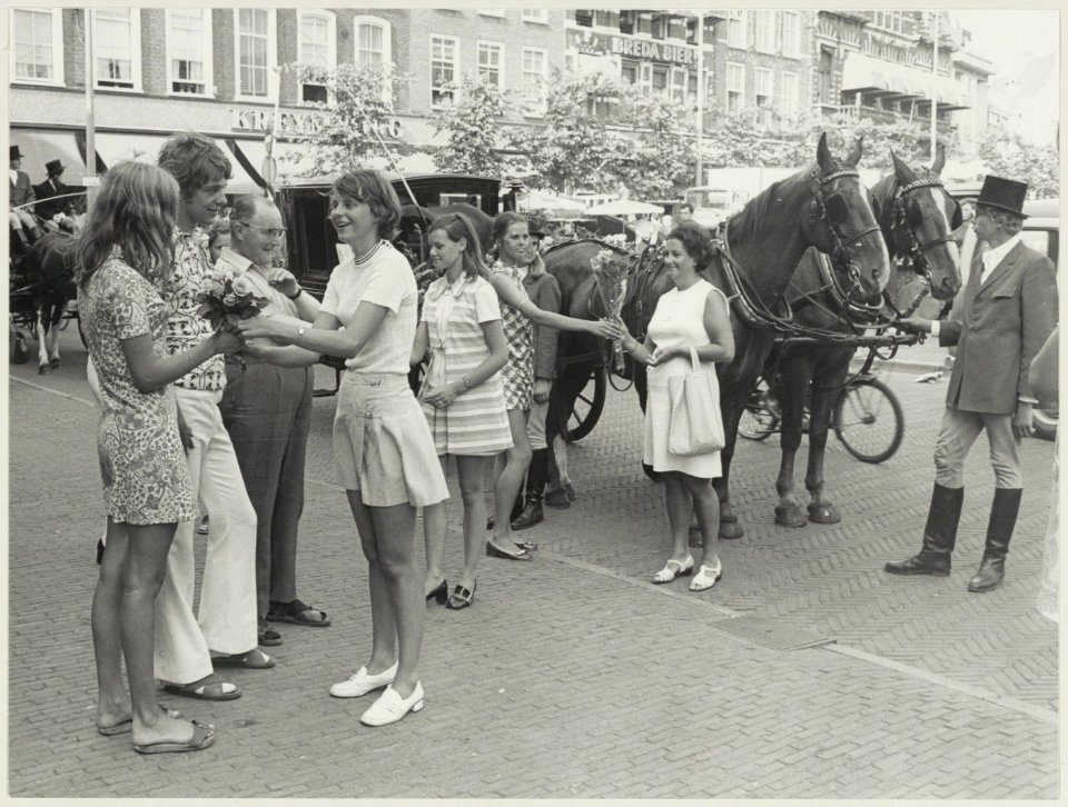 Voorbijgangers krijgen op de Grote Markt bloemen aangeboden t.g.v. het 50-jarig bestaan van de Bloemisten-winkeliersvereniging. NL-HlmNHA 54012042