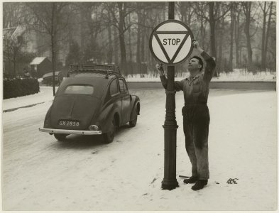 Voor het in werking treden van de nieuwe verkeerswet op 1 januari 1951, wordt op een onbekende locatie het nieuwe stopbord geplaatst. NL-HlmNHA 54010560