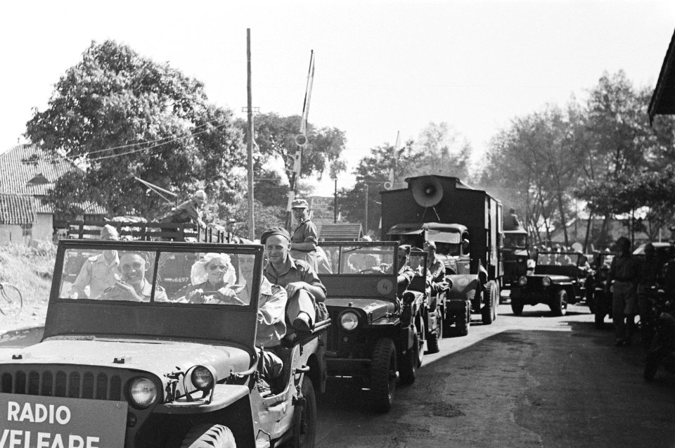 Voor op de jeep een bord met de tekst Radio Welfare, gevolgd door een colonne vo, Bestanddeelnr 249-4-4