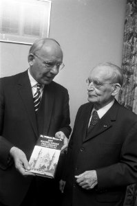 Vondeling houdt boek Het Nederlandse Parlement Vroeger en Nu van dr Drees sr, Bestanddeelnr 928-1490