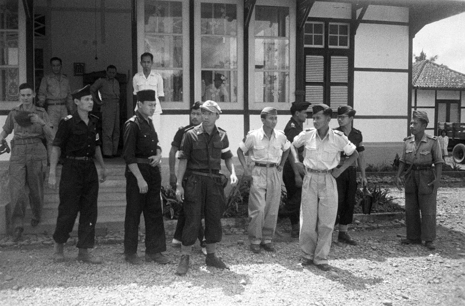 Voor een gebouw stat een grote groep TNI-militairen. In het midden een KNIL-mili, Bestanddeelnr 792