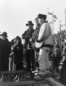 Warschau Drie toeschouwers in streekdracht tijdens een militaire parade, Bestanddeelnr 190-1274