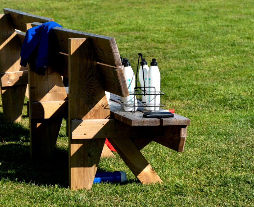 Water bottles on a bench during soccer practice