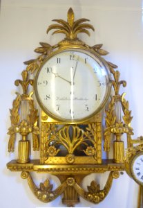 Wall clock, late Gustavian, dial signed Israel Dahlstrom, Stockholm, c. 1800, carved gilt wood - Nordiska museet - Stockholm, Sweden - DSC09977