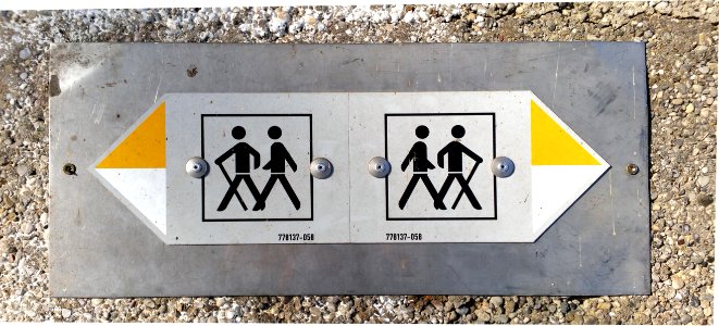 Wanderschild Metall auf Mauer