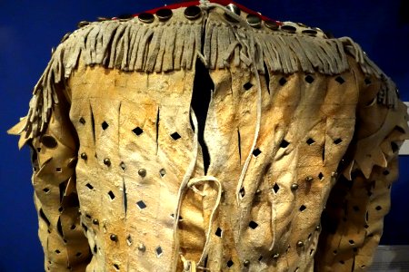 War shirt, Kainai, late 19th century, view 2, hide, weasel skins, brass buttons, red wool trim - Glenbow Museum - DSC00720