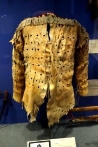 War shirt, Kainai, late 19th century, view 1, hide, weasel skins, brass buttons, red wool trim - Glenbow Museum - DSC00718