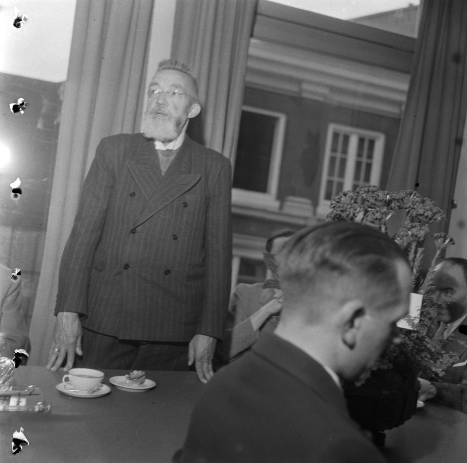 Warenhuis Bijeenkomst Een staande man met baard houdt een toespraak, Bestanddeelnr 900-5335