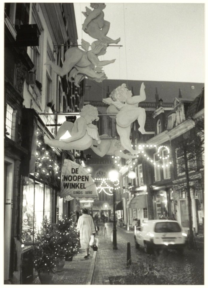 Warmoesstraat in kerstsfeer. Links verlichte etalage van De Knoopenwinkel. NL-HlmNHA 54032187