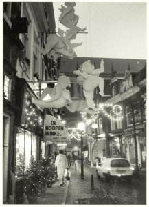 Warmoesstraat in kerstsfeer. Links verlichte etalage van De Knoopenwinkel. NL-HlmNHA 54032187