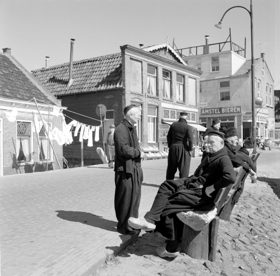 Vissers in Volendam zitten buiten op een bank bij de was op de achtergrond rec…, Bestanddeelnr 254-3828