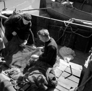 Vissers in Volendam aan boord bezig met de netten, Bestanddeelnr 252-1697
