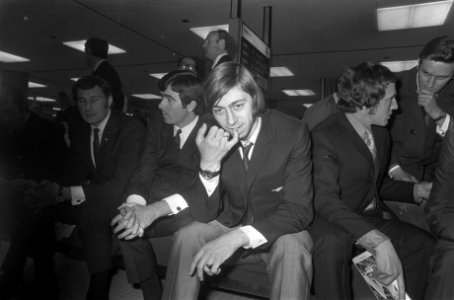 Voetballer Charlie George op een bank op Schiphol, Bestanddeelnr 923-4382
