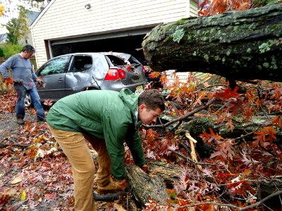 Volunteer assists with tree removal after Hurricane Sandy