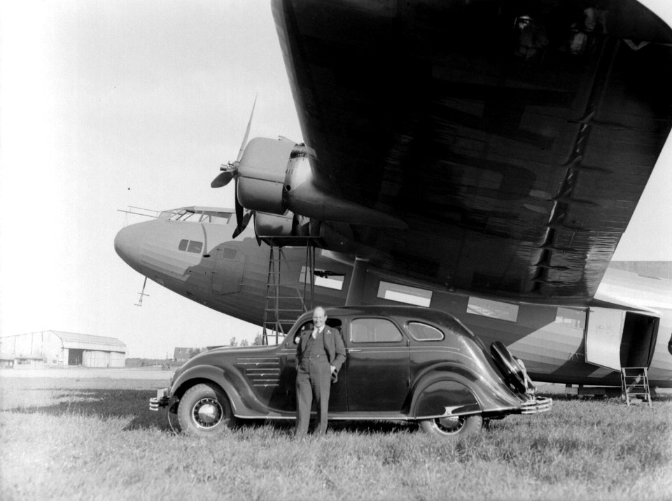 Vliegtuigbouwer Anthony Fokker staand naast een Chrysler Airflow automobiel met , Bestanddeelnr 190-0233
