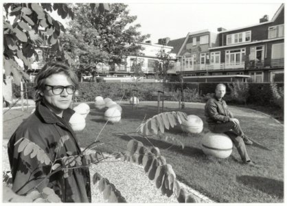 Wijkkunstenaar Tije Domburg en opbouwwerker Dick Bol in het opgeknapte binnenterrein achter de Dr. Schaepmanstraat. NL-HlmNHA 54034006
