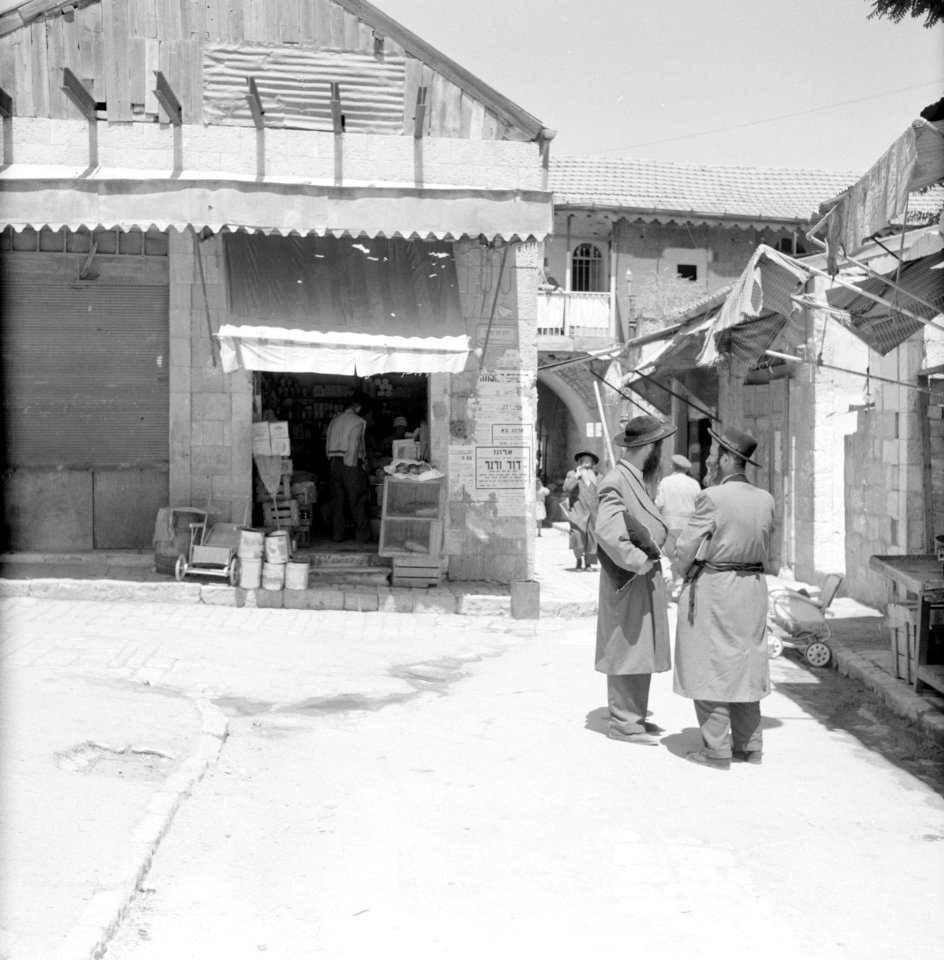 Winkel in de wijk Mea Shearim, een voorbijganger draagt een zitkussen met zich m, Bestanddeelnr 255-2476