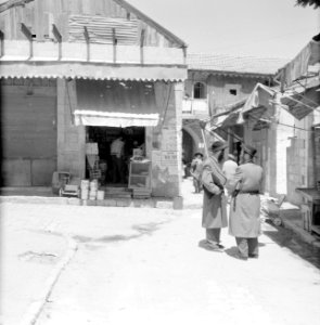 Winkel in de wijk Mea Shearim, een voorbijganger draagt een zitkussen met zich m, Bestanddeelnr 255-2476