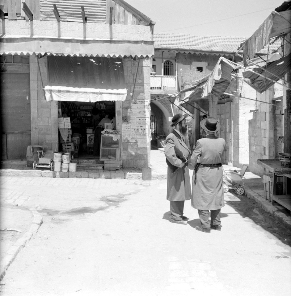 Winkel in de wijk Mea Shearim, een voorbijganger draagt een zitkussen met zich m, Bestanddeelnr 255-2477