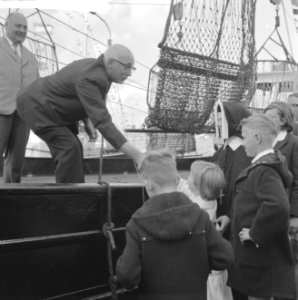 Wieringers in Amsterdam. Burgemeester Schellinger deelt vanaf een boot pakketten, Bestanddeelnr 914-2846