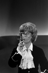 Willeke met bril, pruik en een sigaar in haar rol als modehuis-directrice, Bestanddeelnr 921-6312