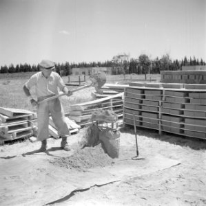 Werknemer van een steenfabriek bezig met het vormen van stenen door het vullen v, Bestanddeelnr 255-1282 photo