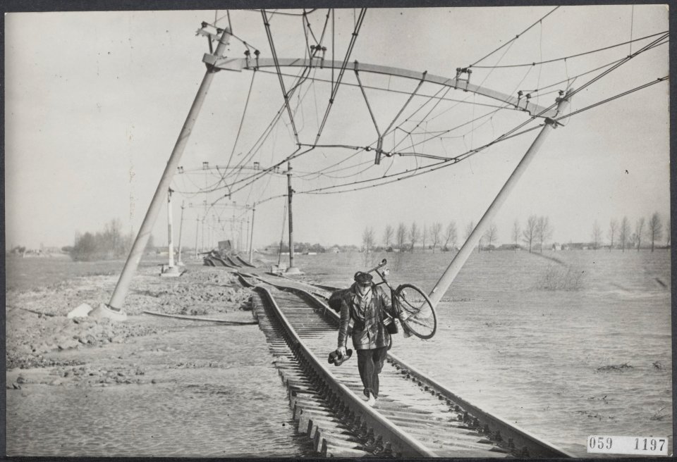 Watersnood 1953. man met fiets op rug loopt over verwoeste spoorbaan en onderge, Bestanddeelnr 059-1197
