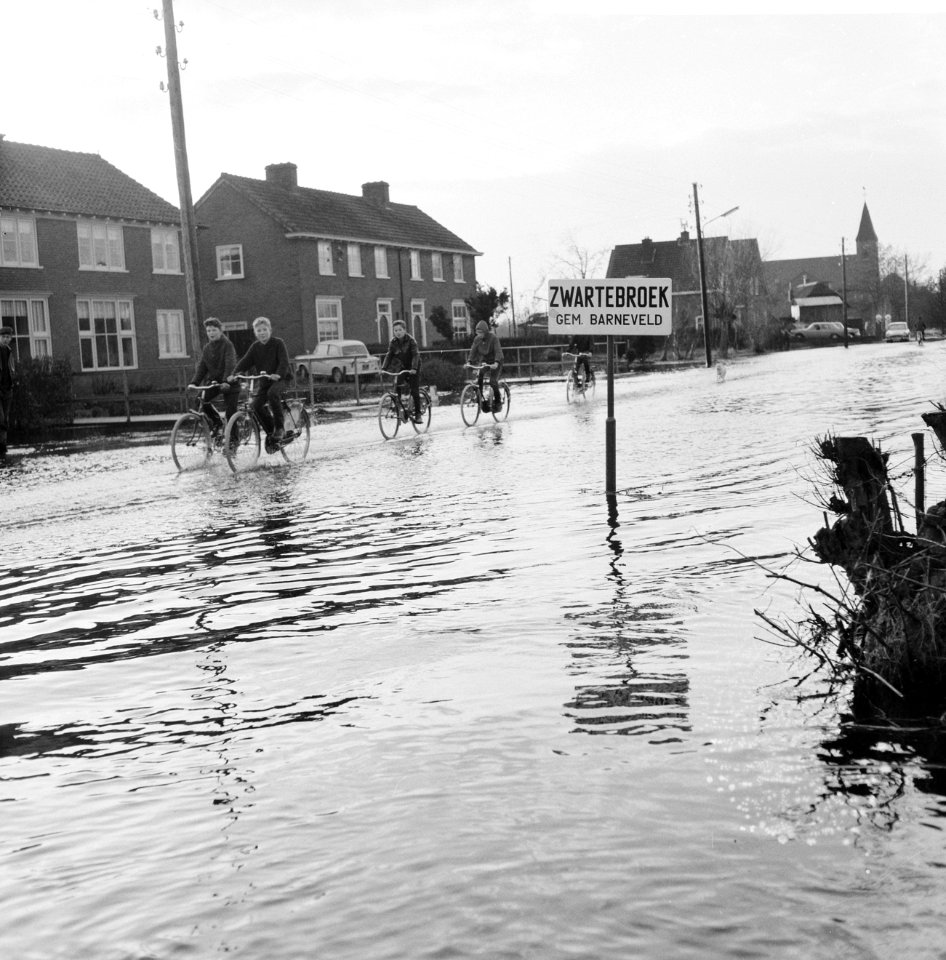 Wateroverlast in de Gelderse Vallei kinderen fietsend over de ondergelopen stra, Bestanddeelnr 918-5505