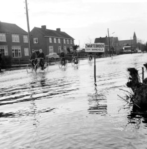 Wateroverlast in de Gelderse Vallei kinderen fietsend over de ondergelopen stra, Bestanddeelnr 918-5505
