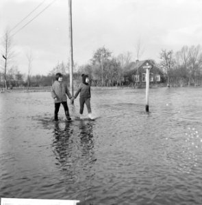 Wateroverlast in de Gelderse Vallei kinderen die hand in hand door het water wa, Bestanddeelnr 918-5503