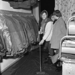 Wateroverlast te Rotterdam vrouw tijdens het dweilen in een winkel aan de Oranj, Bestanddeelnr 918-5335