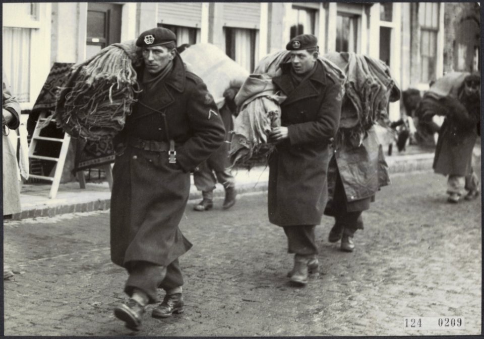 Watersnoodramp 1953. Nederlandse militairen sjouwen met bundels juten zakken doo, Bestanddeelnr 124-0209