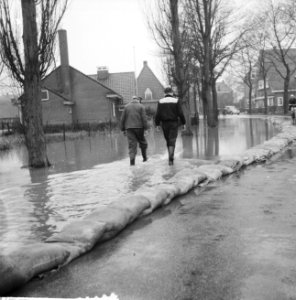Watersnood in Borculo, jongens lopen door water om hun hu te bereiken, Bestanddeelnr 911-8525