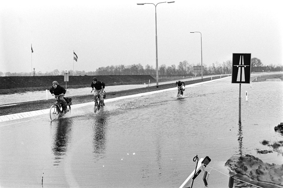 Water-overlast in Drenthe door regenval en smeltwater uit Duitsland, drie fietsers op A-28 (autosnelweg bij Meppel), Bestanddeelnr 931-3711
