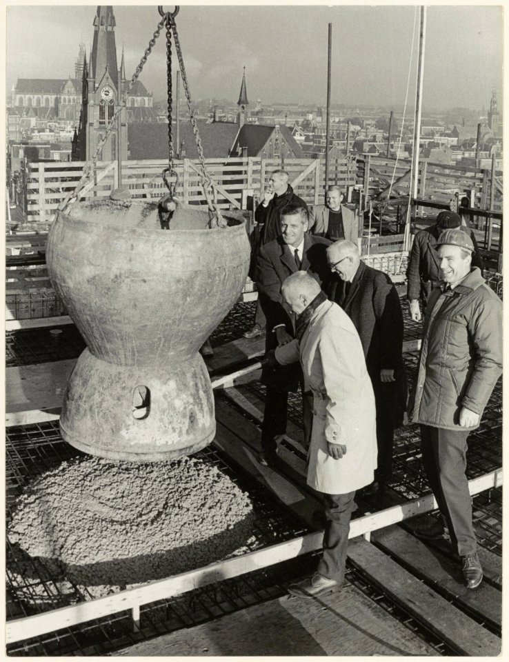 Wethouder W. van Liemt ( met bril) bij het bereiken van het hoogste punt van het nieuwe gebouw Koningstein aan het Zuider Buiten Spaarne 22. Naast hem de beide directeuren van Openbare Werke, NL-HlmNHA 54003668