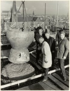 Wethouder W. van Liemt ( met bril) bij het bereiken van het hoogste punt van het nieuwe gebouw Koningstein aan het Zuider Buiten Spaarne 22. Naast hem de beide directeuren van Openbare Werke, NL-HlmNHA 54003668