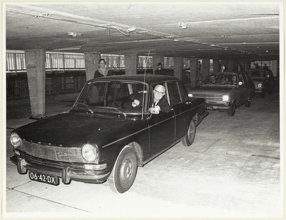Wethouder W. van Liemt, zittend in zijn auto, opent de parkeergarage aan de Raaks. NL-HlmNHA 54003658