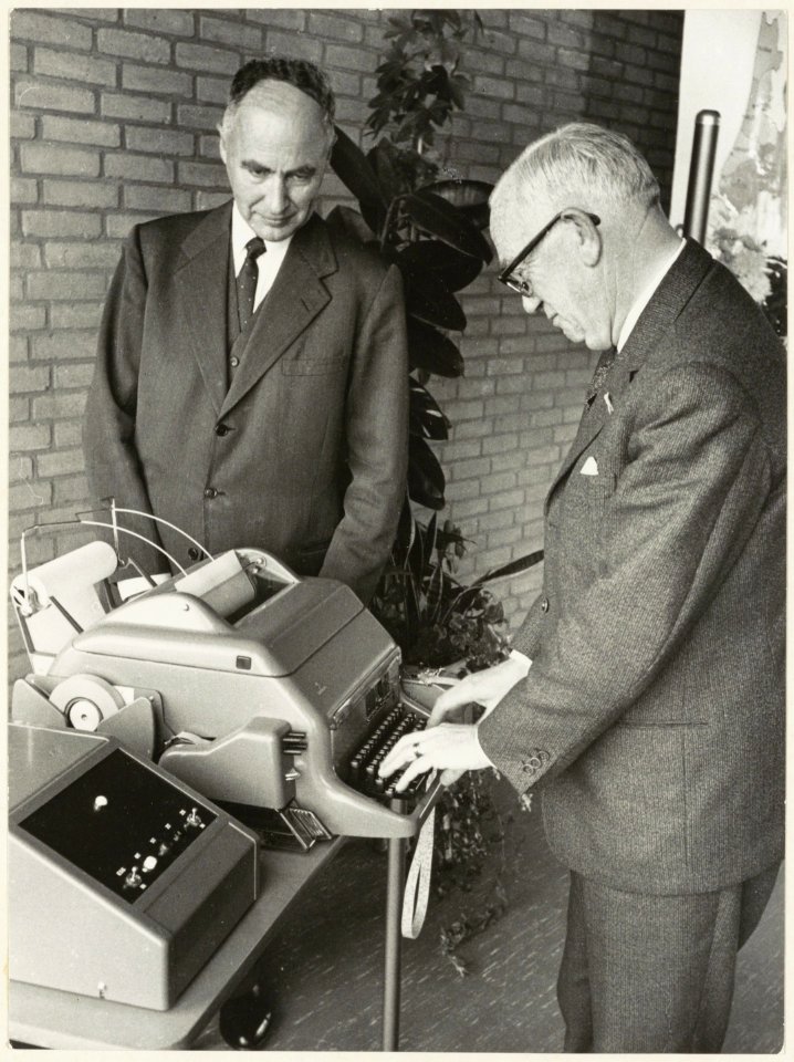 Wethouder W. van Liemt stelt het nieuwe telexapparaat in het postkantoor aan de Raaks in werking. NL-HlmNHA 54003659