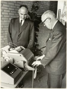 Wethouder W. van Liemt stelt het nieuwe telexapparaat in het postkantoor aan de Raaks in werking. NL-HlmNHA 54003659