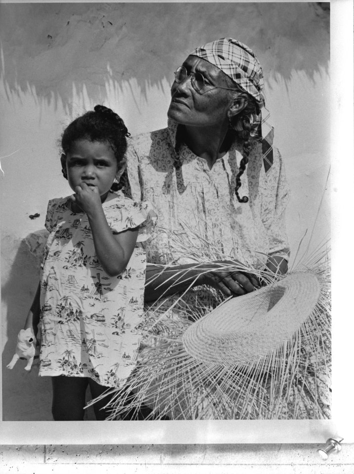 West-Indië, Curaçao, San Pedro. Zwarte vrouw met kind vlecht een strooien hoed, Bestanddeelnr 935-1521